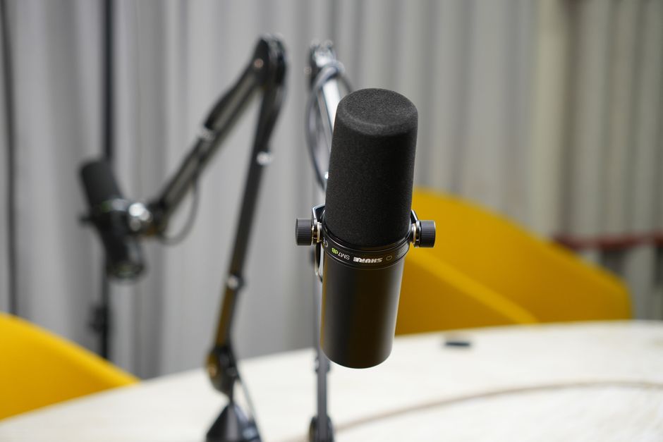 Dynamic podcast microphone on a boom arm at a desk